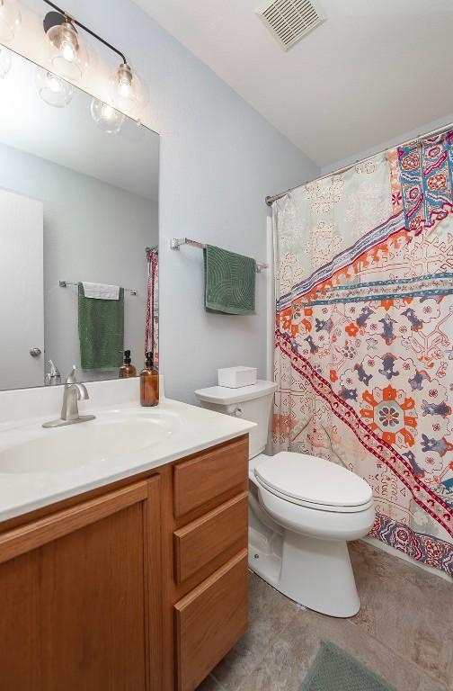 full bathroom with tile patterned flooring, visible vents, toilet, and vanity