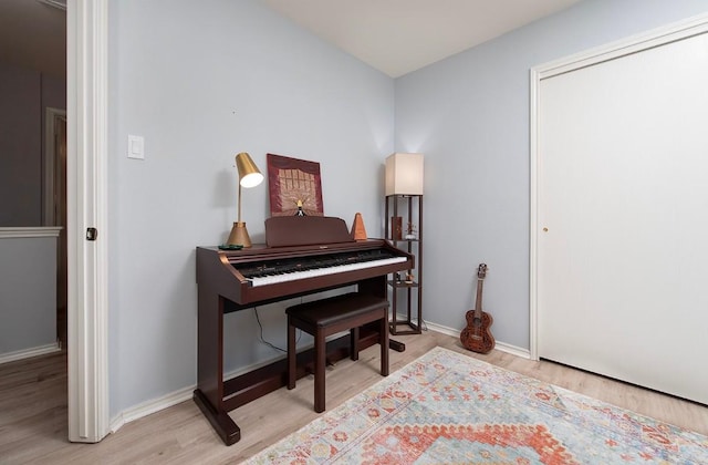 sitting room with baseboards and wood finished floors