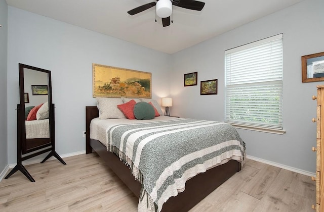 bedroom with light wood-type flooring, baseboards, and ceiling fan