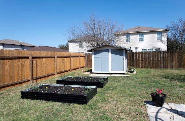 view of yard featuring an outbuilding, a storage shed, a vegetable garden, and a fenced backyard