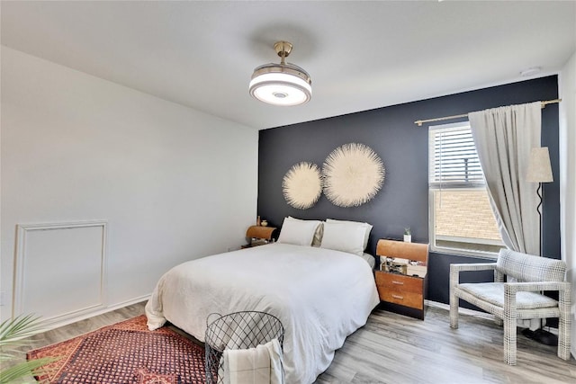 bedroom with baseboards and wood finished floors