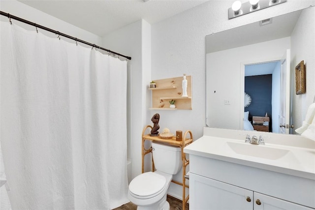 ensuite bathroom with visible vents, vanity, toilet, and ensuite bathroom