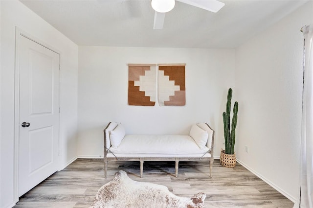 sitting room featuring ceiling fan, baseboards, and wood finished floors