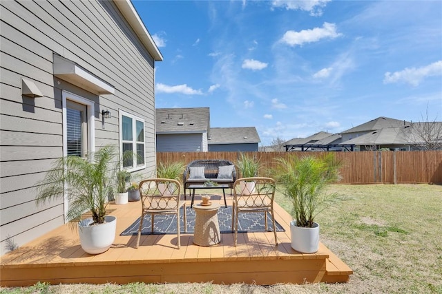 deck featuring area for grilling, a lawn, and fence