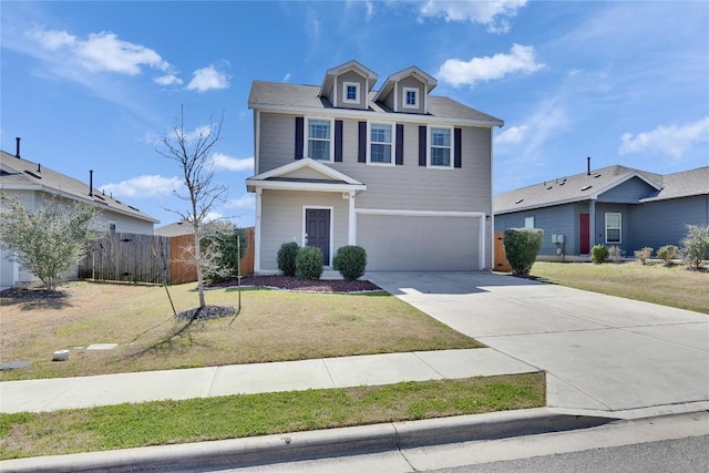 american foursquare style home with an attached garage, concrete driveway, a front yard, and fence