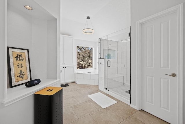 bathroom featuring tile patterned flooring, a shower stall, and a bath