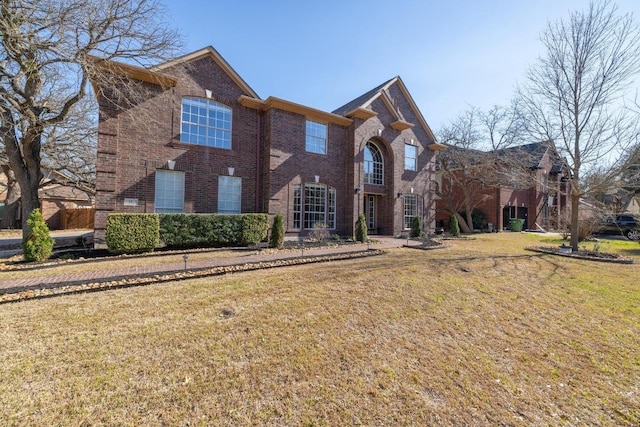 view of front of home featuring brick siding and a front lawn