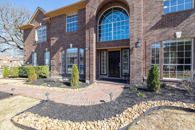 view of exterior entry featuring brick siding