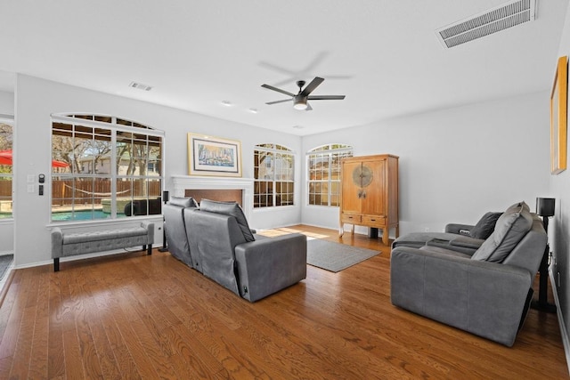 living area with wood finished floors, visible vents, and ceiling fan