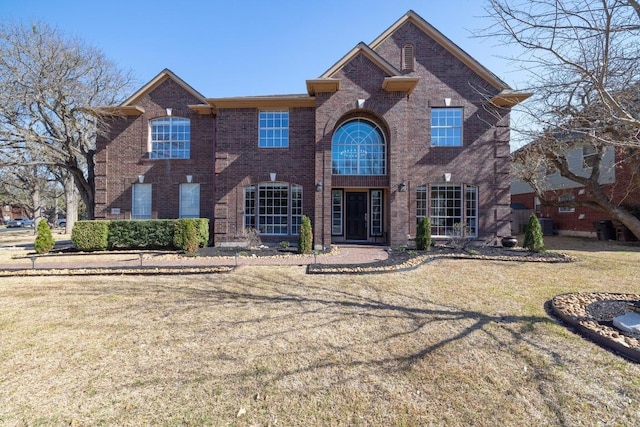 view of front of property with brick siding and a front lawn