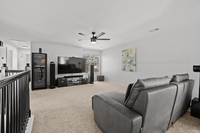 living area featuring baseboards, visible vents, carpet floors, attic access, and ceiling fan