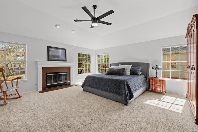 carpeted bedroom featuring baseboards, ceiling fan, a fireplace with flush hearth, vaulted ceiling, and recessed lighting