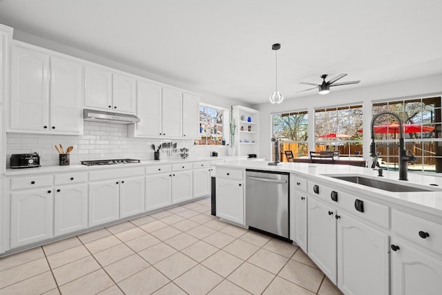 kitchen featuring under cabinet range hood, dishwasher, gas cooktop, a ceiling fan, and a sink