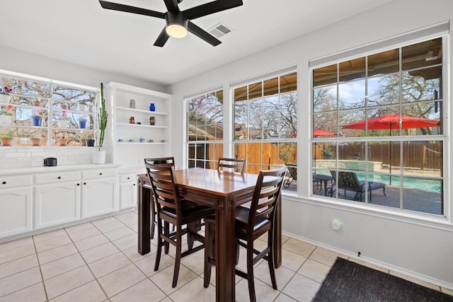 dining area with light tile patterned floors, visible vents, baseboards, and a ceiling fan