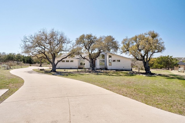 view of front of property with concrete driveway and a front lawn