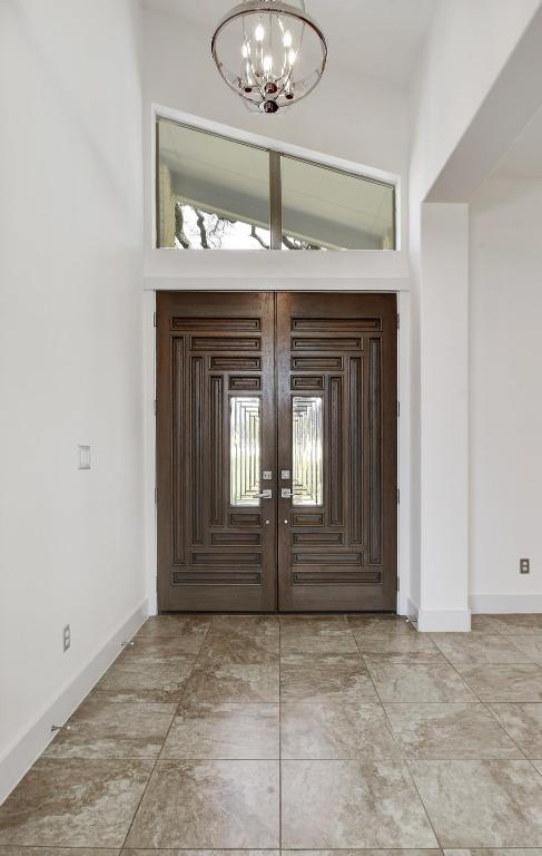 foyer featuring a chandelier and baseboards