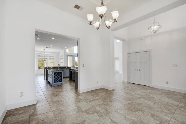 interior space with a chandelier, visible vents, and baseboards