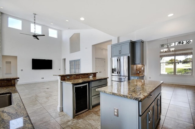 kitchen featuring a notable chandelier, a kitchen island, open floor plan, wine cooler, and stainless steel fridge with ice dispenser