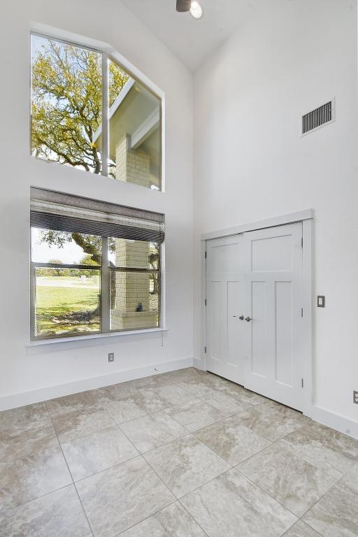 entrance foyer featuring visible vents, baseboards, and a high ceiling