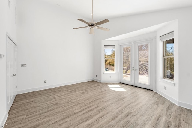 spare room with a healthy amount of sunlight, french doors, baseboards, and wood finished floors