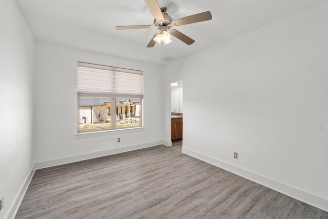 unfurnished room featuring light wood-style flooring, baseboards, and ceiling fan