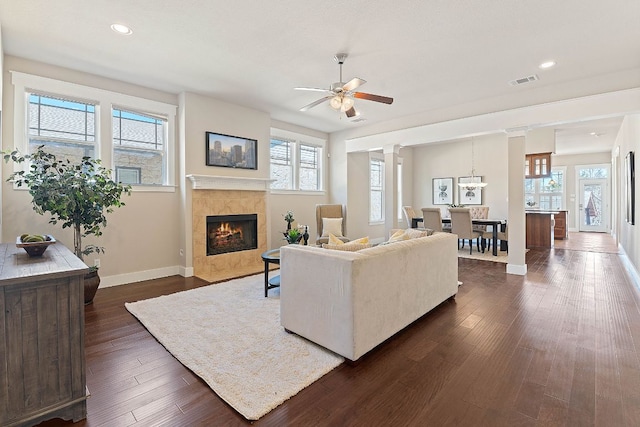 living area featuring healthy amount of natural light, baseboards, a tiled fireplace, ceiling fan, and recessed lighting