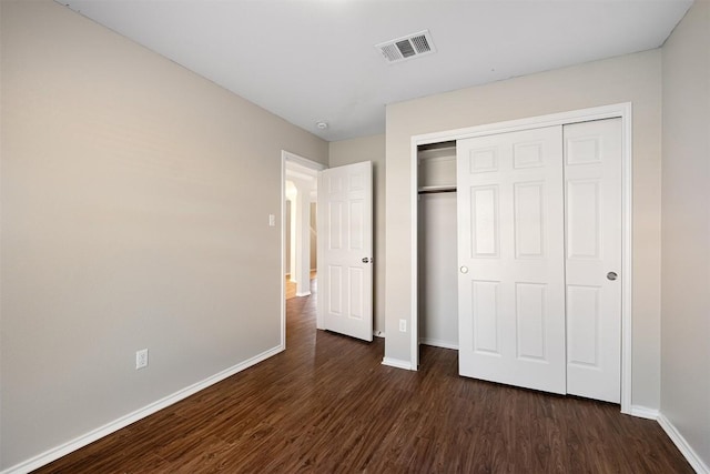 100 Snowy Egret Ln, Leander, TX 78641 - unfurnished bedroom with dark wood finished floors, baseboards, and a closet