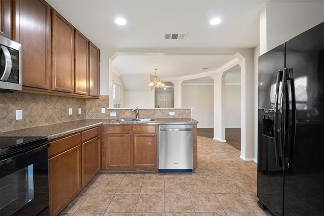100 Snowy Egret Ln, Leander, TX 78641 - kitchen featuring black appliances, a sink, arched walkways, a chandelier, and decorative backsplash