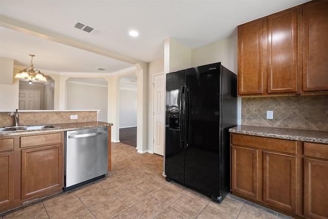 100 Snowy Egret Ln, Leander, TX 78641 - kitchen with black fridge, dishwasher, a sink, a chandelier, and brown cabinets