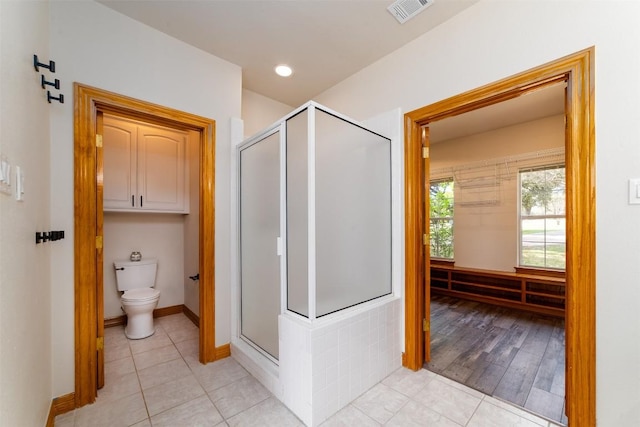 bathroom with baseboards, visible vents, a stall shower, tile patterned flooring, and toilet