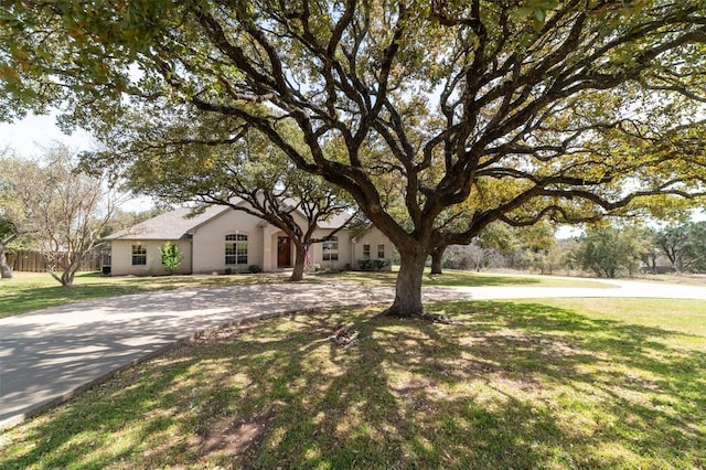 view of front of house with a front lawn, fence, and driveway