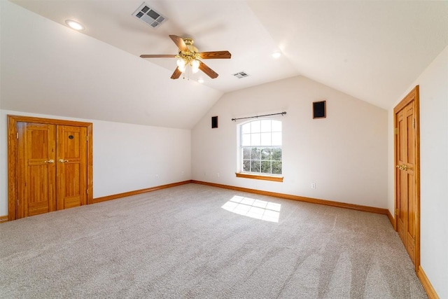 additional living space featuring visible vents, lofted ceiling, light colored carpet, and baseboards