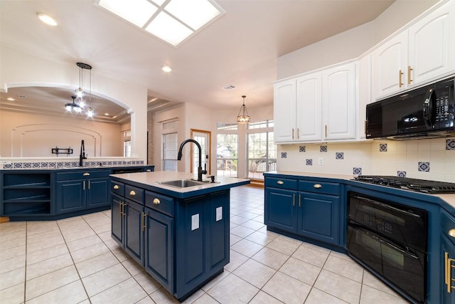 kitchen featuring gas cooktop, an inviting chandelier, blue cabinetry, a sink, and black microwave