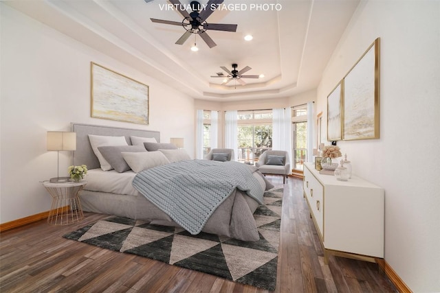 bedroom with recessed lighting, baseboards, a tray ceiling, and wood finished floors