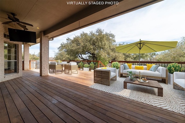 wooden terrace with ceiling fan, outdoor dining space, and an outdoor hangout area