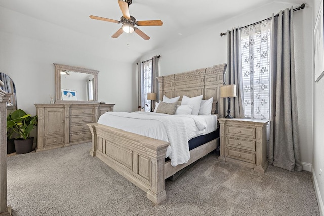 bedroom with a ceiling fan, lofted ceiling, multiple windows, and light colored carpet