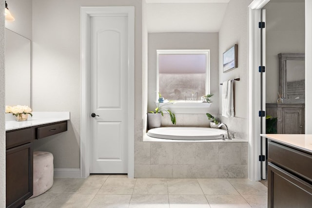 bathroom with tile patterned floors, vanity, and a garden tub