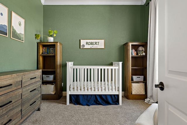 carpeted bedroom with crown molding and a nursery area