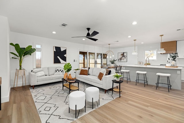 living area featuring recessed lighting, visible vents, light wood-style floors, and a ceiling fan