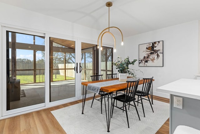 dining space with light wood-style floors and french doors