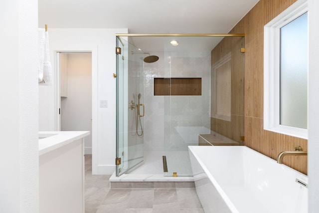 bathroom with a shower stall and a freestanding tub