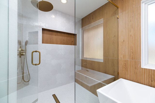 bathroom featuring a sink, tiled shower, and tile walls