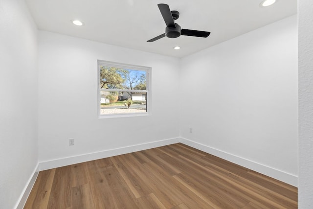 spare room featuring a ceiling fan, baseboards, and wood finished floors