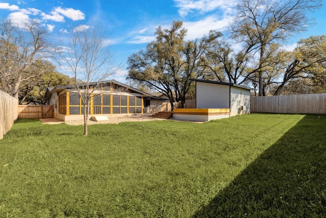 view of yard featuring a fenced backyard and a sunroom