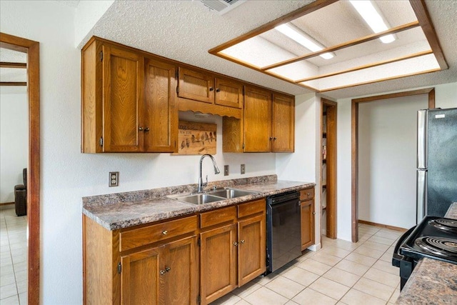 kitchen with a sink, dark countertops, black appliances, and brown cabinetry