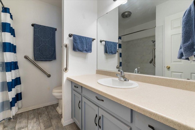 bathroom featuring toilet, wood finished floors, a shower with shower curtain, baseboards, and vanity