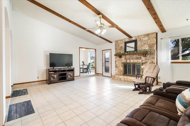 tiled living room featuring baseboards, a fireplace, ceiling fan, a textured ceiling, and beamed ceiling