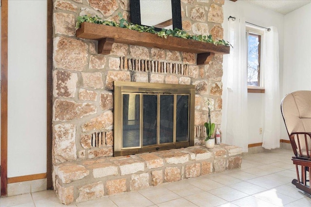 interior details featuring a glass covered fireplace and baseboards