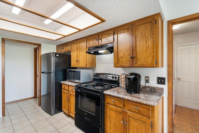 kitchen featuring brown cabinets, black appliances, under cabinet range hood, a textured ceiling, and light tile patterned floors