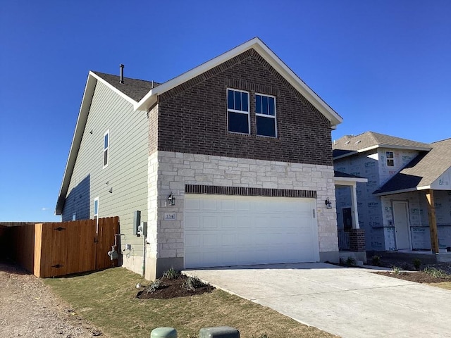 traditional-style house with an attached garage, fence, stone siding, and driveway